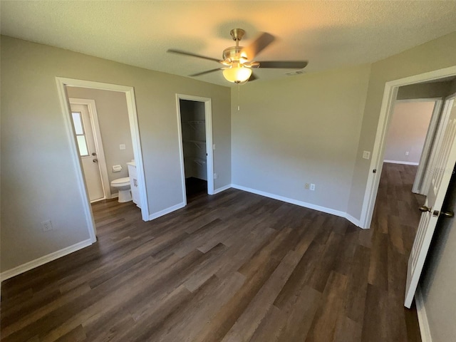 7507 Sandstone Dr, Orlando, FL 32836 - unfurnished bedroom featuring dark wood-style flooring, a closet, a spacious closet, baseboards, and a textured ceiling