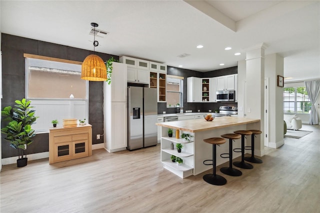 7551 Bear Claw Run, Orlando, FL 32825 - kitchen with open shelves, wooden counters, stainless steel appliances, light wood-style floors, and recessed lighting