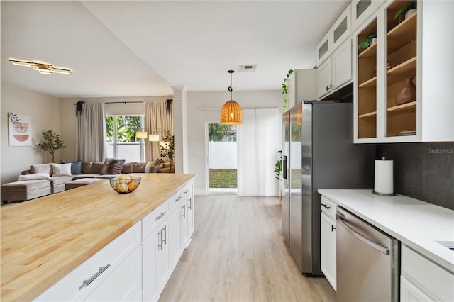 7551 Bear Claw Run, Orlando, FL 32825 - kitchen featuring stainless steel appliances, light wood-style flooring, open floor plan, glass insert cabinets, and white cabinets