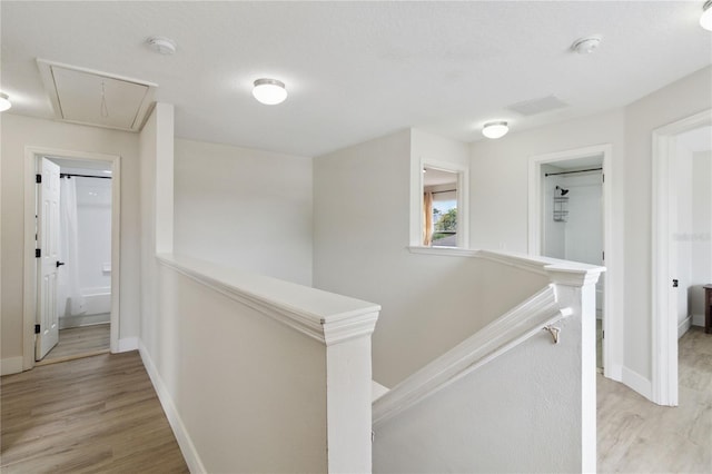 7551 Bear Claw Run, Orlando, FL 32825 - hall featuring an upstairs landing, attic access, light wood-type flooring, and baseboards