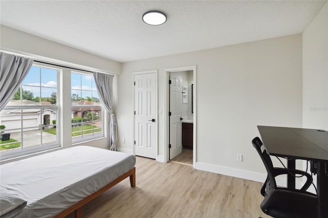 7551 Bear Claw Run, Orlando, FL 32825 - bedroom with baseboards, light wood-style floors, and ensuite bath