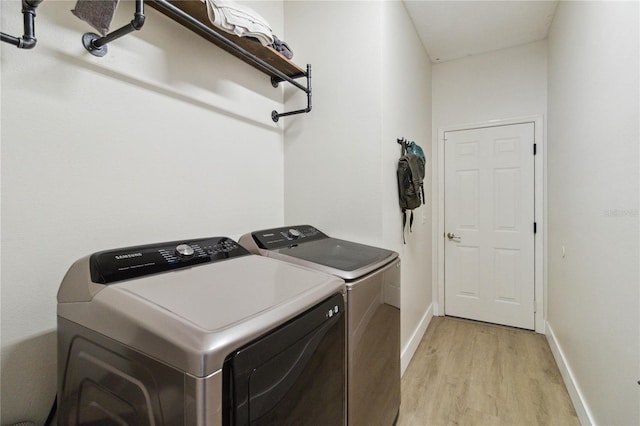 7551 Bear Claw Run, Orlando, FL 32825 - laundry room with washer and clothes dryer, light wood-style flooring, and baseboards