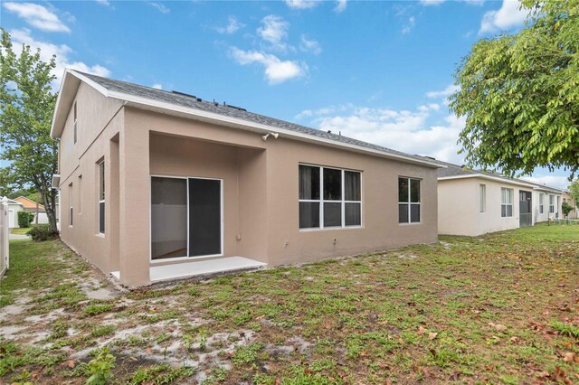 7551 Bear Claw Run, Orlando, FL 32825 - back of property featuring stucco siding and a lawn