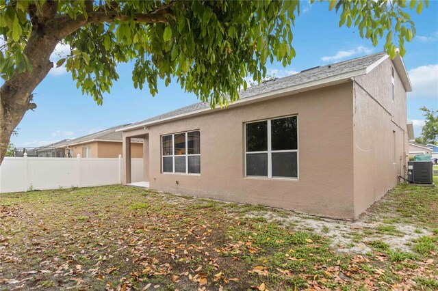 7551 Bear Claw Run, Orlando, FL 32825 - back of property with central AC unit, stucco siding, and a shingled roof