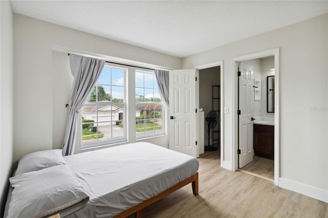 7551 Bear Claw Run, Orlando, FL 32825 - bedroom with light wood-type flooring, baseboards, and connected bathroom