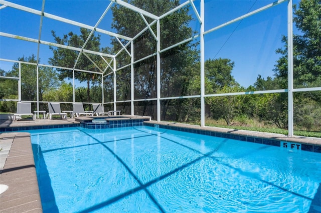 view of pool with a pool with connected hot tub and glass enclosure
