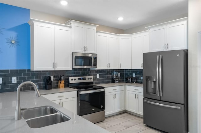kitchen featuring stainless steel appliances, a sink, light countertops, and recessed lighting