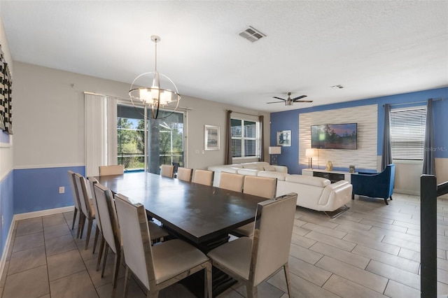 tiled dining room featuring a chandelier, baseboards, and ceiling fan