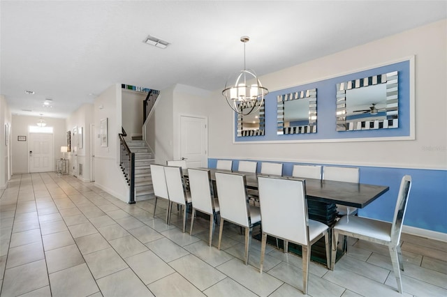 dining area featuring stairs, a chandelier, tile patterned floors, and baseboards
