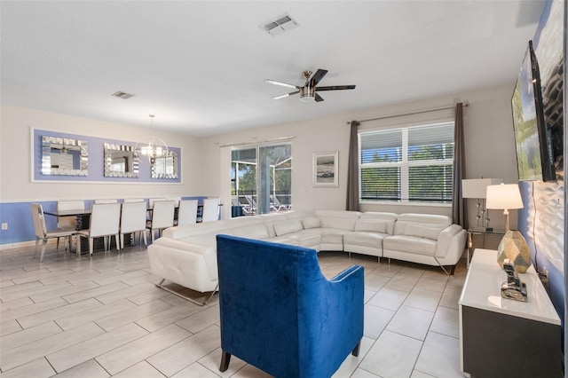 living area featuring a chandelier, a ceiling fan, and healthy amount of natural light