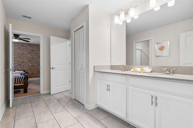 bathroom with tile patterned flooring, double vanity, ceiling fan, and baseboards