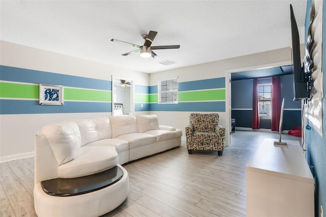 living room with ceiling fan, light wood-type flooring, and baseboards