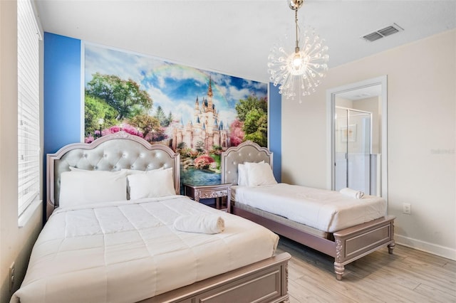 bedroom featuring a chandelier, light wood-type flooring, and baseboards