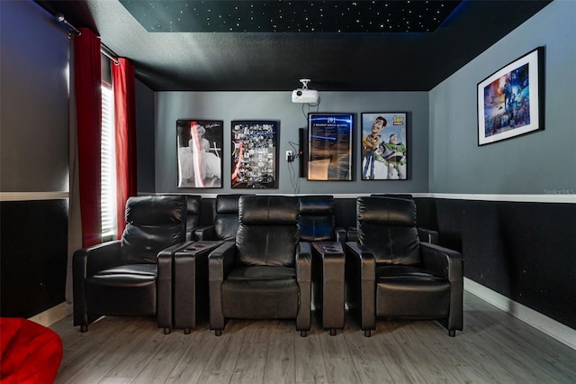 cinema room featuring wood finished floors, healthy amount of natural light, and baseboards