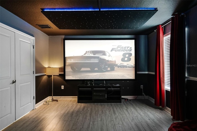 home theater featuring wood finished floors and baseboards