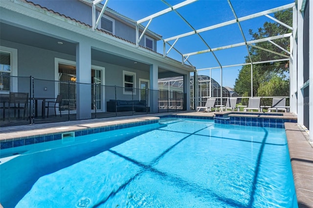 view of pool featuring a patio, a pool with connected hot tub, and a lanai
