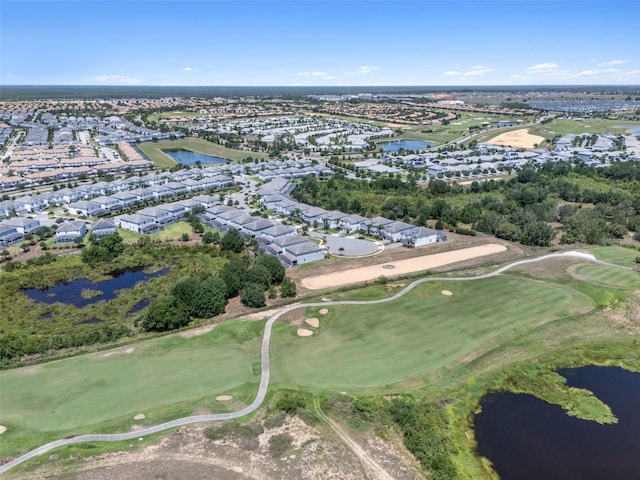 aerial view of property and surrounding area featuring nearby suburban area, a golf club, and a nearby body of water