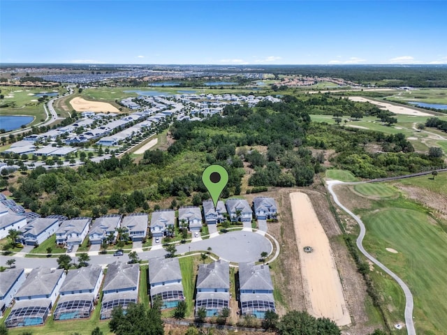 aerial view of property's location featuring a large body of water, a golf club, and nearby suburban area