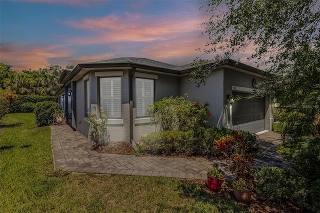 532 Casanova Ct, Kissimmee, FL 34759 - view of side of home with stucco siding, a garage, and a lawn