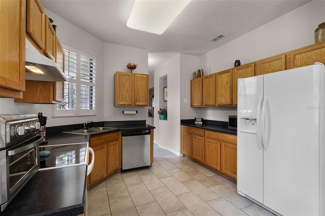 532 Casanova Ct, Kissimmee, FL 34759 - kitchen featuring stainless steel appliances, under cabinet range hood, a sink, dark countertops, and a textured ceiling