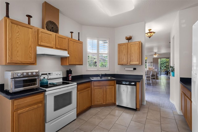 532 Casanova Ct, Kissimmee, FL 34759 - kitchen with stainless steel dishwasher, electric range, under cabinet range hood, a sink, and dark countertops