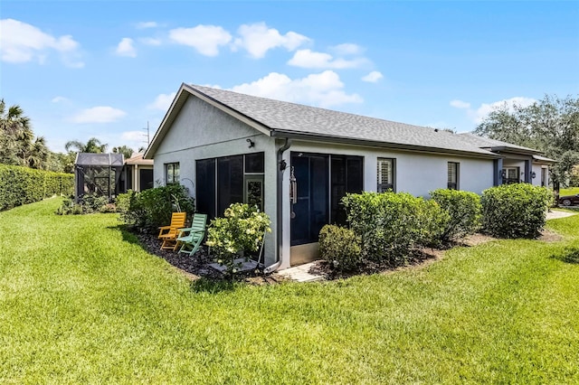 532 Casanova Ct, Kissimmee, FL 34759 - back of property with stucco siding, a yard, a sunroom, and roof with shingles