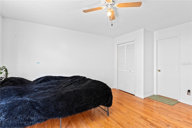 2500 Derby Dr, Kissimmee, FL 34744 - bedroom featuring light wood-style flooring, a textured ceiling, a closet, ceiling fan, and baseboards