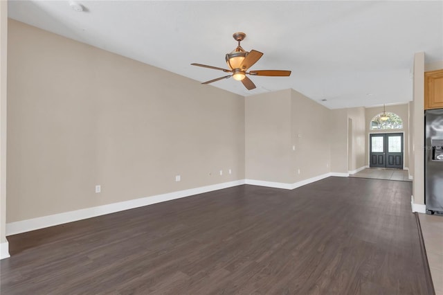 unfurnished living room with dark wood-type flooring, baseboards, and ceiling fan