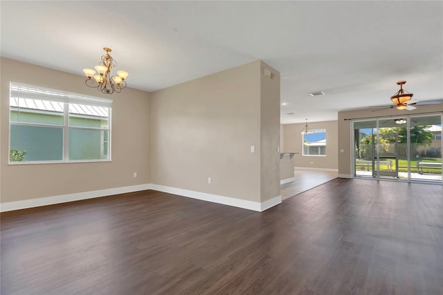 spare room with a chandelier, baseboards, dark wood-style floors, and a ceiling fan