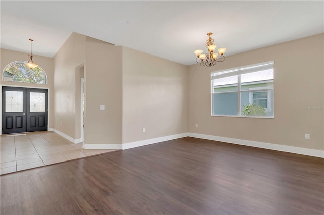 entrance foyer featuring a chandelier, wood finished floors, and baseboards