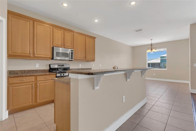 kitchen with stainless steel appliances, a breakfast bar, light tile patterned flooring, a chandelier, and recessed lighting