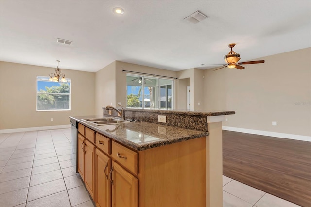 kitchen featuring a sink, light tile patterned floors, healthy amount of natural light, baseboards, and recessed lighting
