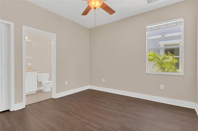 spare room featuring wood finished floors, a ceiling fan, and baseboards