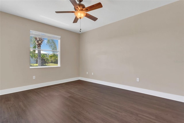 spare room featuring baseboards, dark wood-type flooring, and ceiling fan