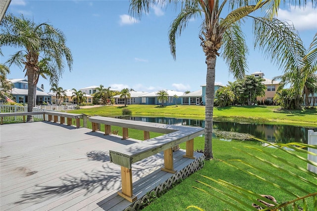dock featuring a residential view, a water view, and a yard
