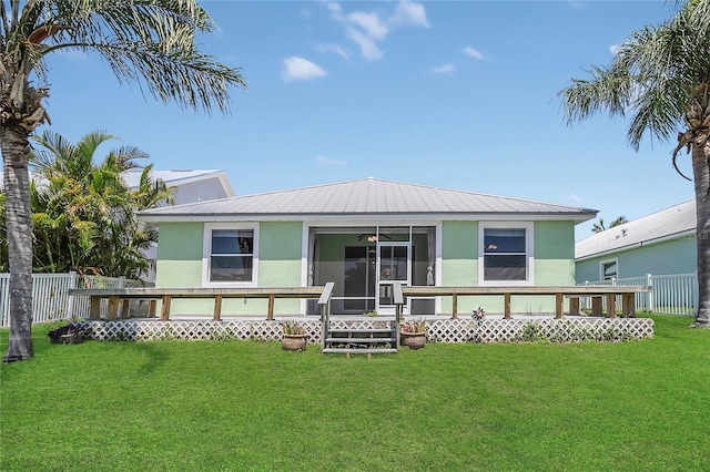 back of property featuring stucco siding, a sunroom, and metal roof