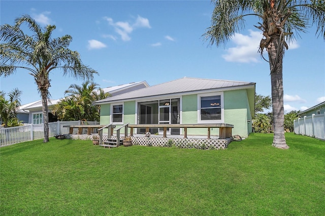rear view of house with stucco siding and a sunroom