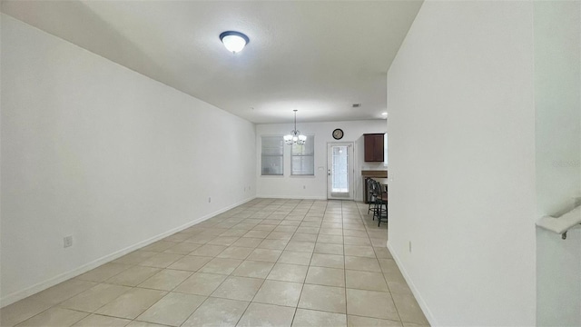 4450 Capital Blvd, Saint Cloud, FL 34769 - empty room with light tile patterned floors, a chandelier, and baseboards