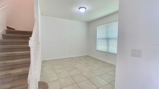 4450 Capital Blvd, Saint Cloud, FL 34769 - unfurnished room featuring stairs, light tile patterned floors, and baseboards
