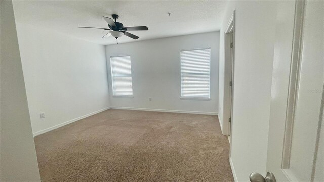 4450 Capital Blvd, Saint Cloud, FL 34769 - empty room featuring light colored carpet, baseboards, and a ceiling fan