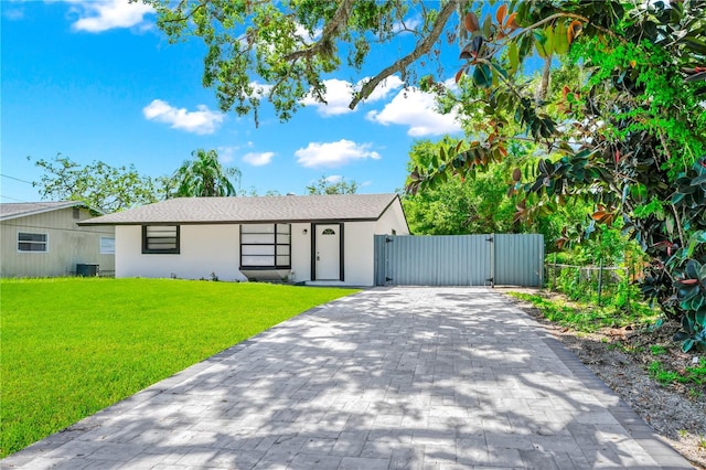 228 Ring Rd, Orlando, FL 32811 - ranch-style house featuring a gate, stucco siding, decorative driveway, and central AC unit