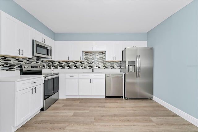 228 Ring Rd, Orlando, FL 32811 - kitchen featuring stainless steel appliances, a sink, light countertops, tasteful backsplash, and white cabinets