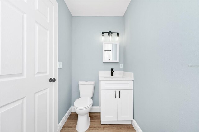 228 Ring Rd, Orlando, FL 32811 - bathroom featuring vanity, wood finished floors, toilet, and baseboards