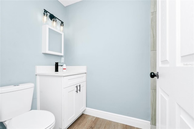 228 Ring Rd, Orlando, FL 32811 - bathroom with toilet, vanity, wood finished floors, and baseboards
