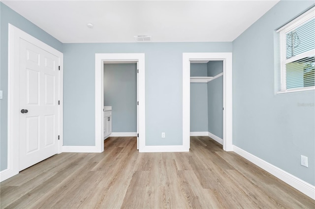 228 Ring Rd, Orlando, FL 32811 - unfurnished bedroom featuring light wood-type flooring, baseboards, a spacious closet, and a closet