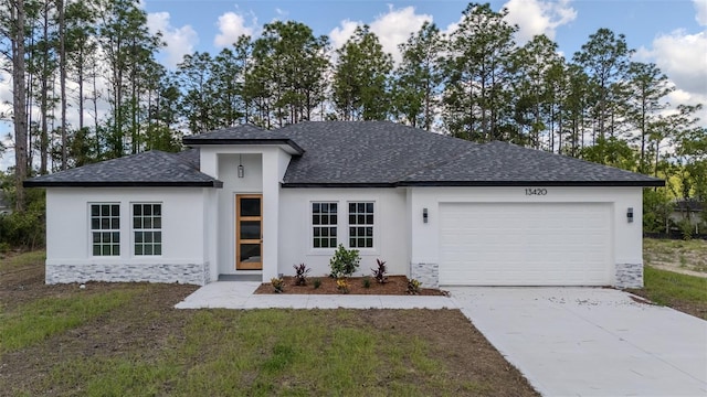 view of front of property with a shingled roof, an attached garage, concrete driveway, stucco siding, and stone siding