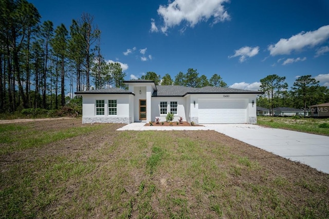 view of front of property featuring stucco siding, an attached garage, stone siding, driveway, and a front yard