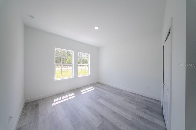 unfurnished room featuring light wood-type flooring and baseboards