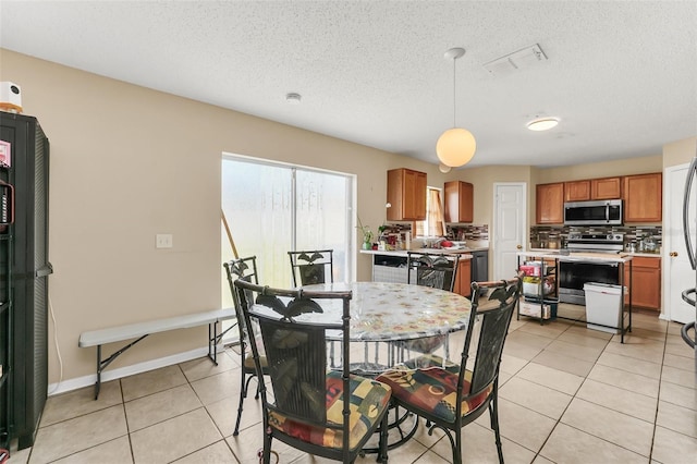 510 Lobelia Dr, Davenport, FL 33837 - dining space with light tile patterned floors, a textured ceiling, and baseboards