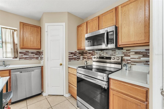 510 Lobelia Dr, Davenport, FL 33837 - kitchen featuring stainless steel appliances, backsplash, light countertops, a textured ceiling, and light tile patterned floors